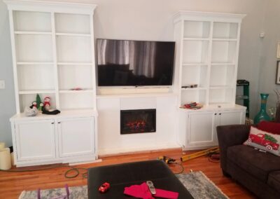 This built-in bookshelf and fireplace ensemble combines clean-lined charm with cozy functionality, creating a bright and inviting focal point for any living space.